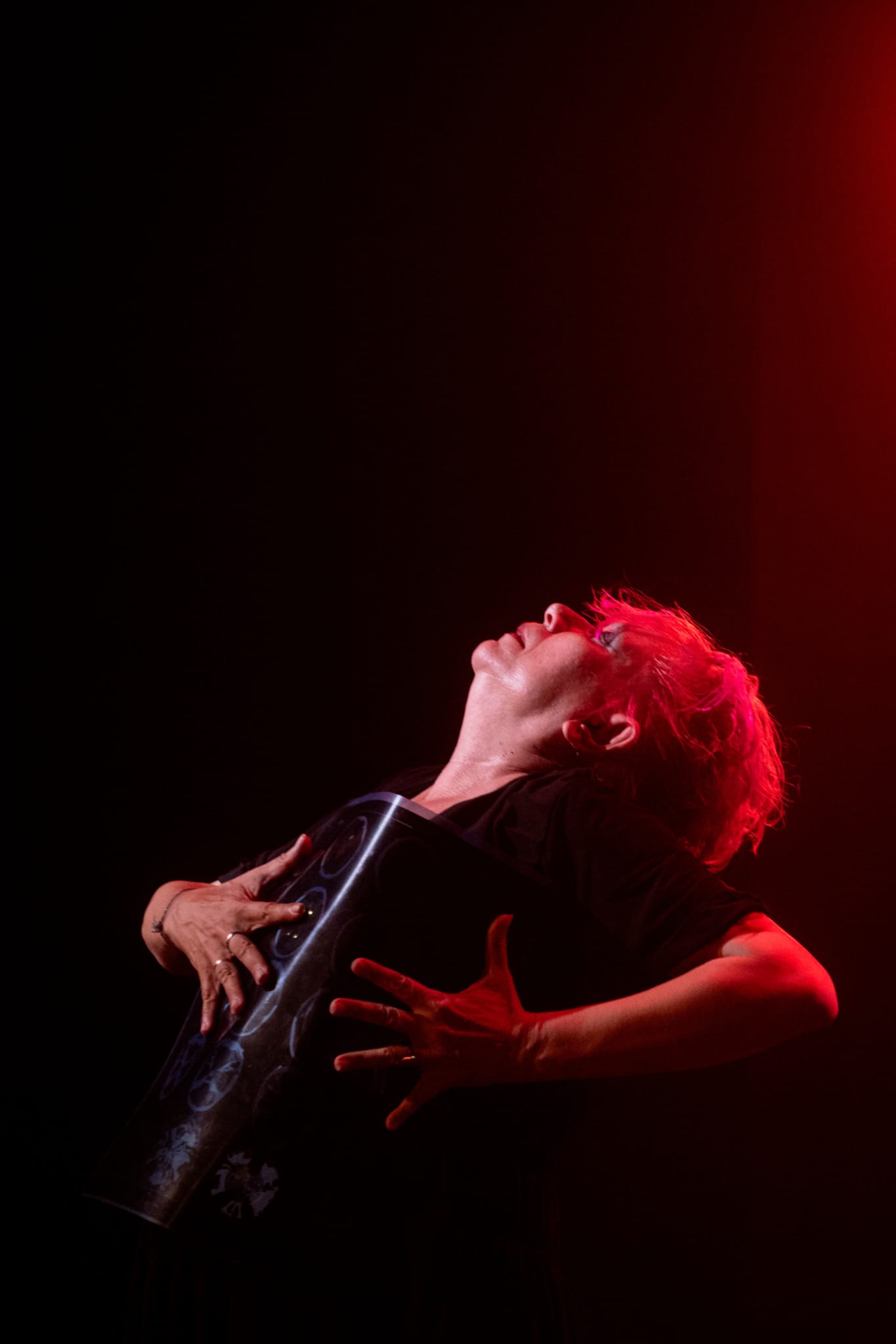 Rita Alves em gesto expressivo sob luz vermelha