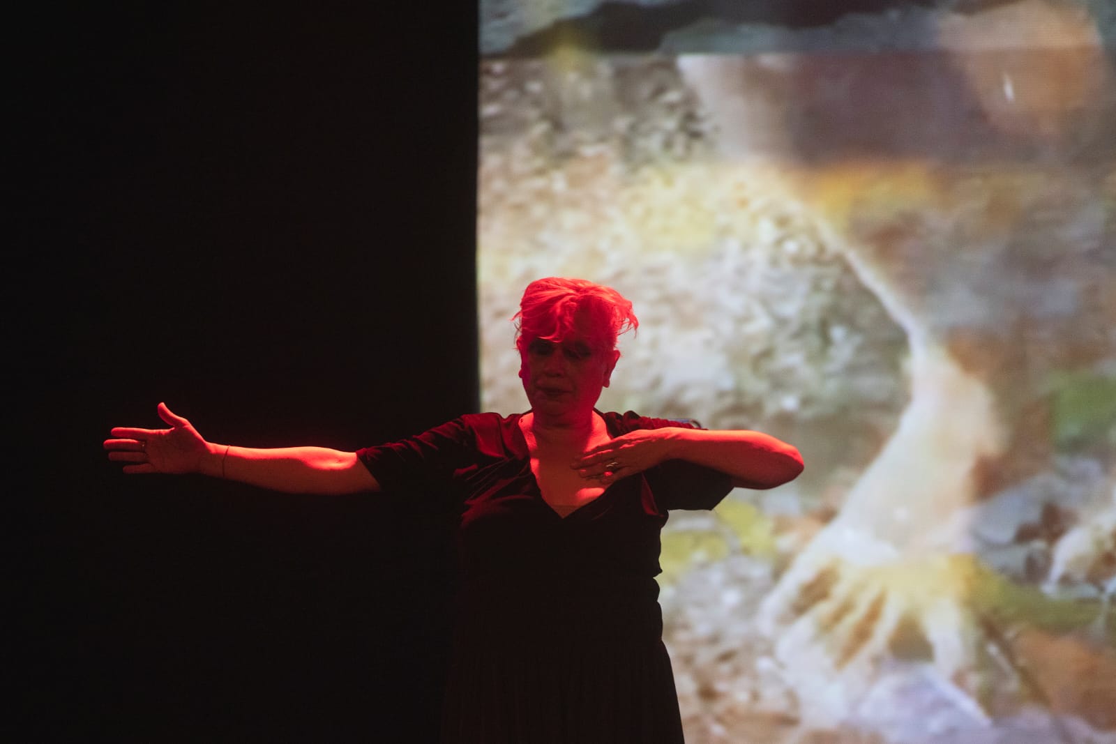 Rita Alves em performance diante de uma projeção